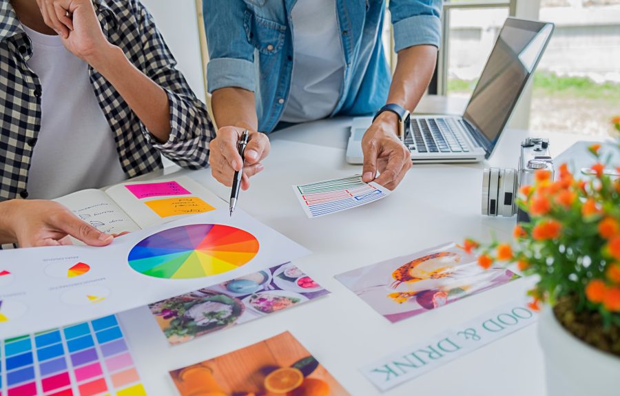 Asian advertising designer creative start-up team discussing ideas in office.