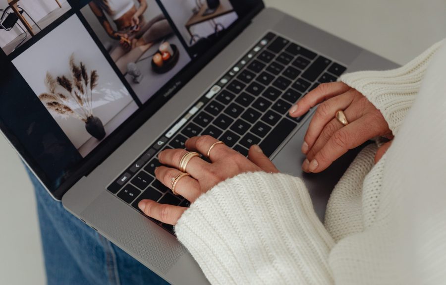 kaboompics_woman-in-white-sweater-gold-rings-jewelry-jeans-laptop-work-29438