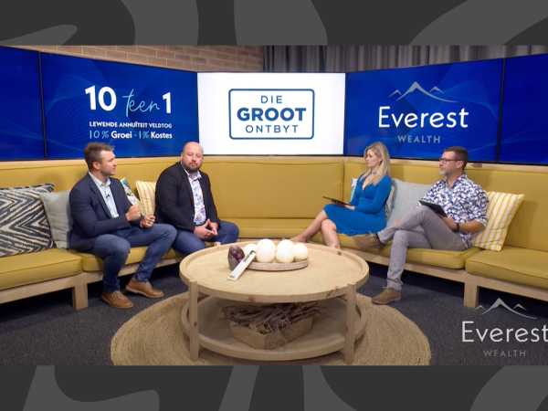 Four people are sitting on yellow couches in a studio set for "Die Groot Ontbyt." Two people appear to interview two others, with blue branding in the background.