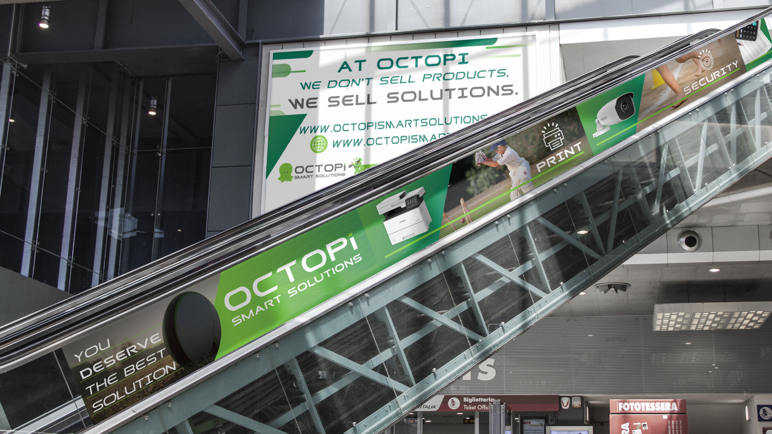 Escalator with advertising panels for OCTOPI Smart Solutions, featuring images of security cameras and printers. Banner above reads: 'We don't sell products, we sell solutions.' Modern, tech-focused tone.
